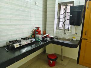 a kitchen counter with a stove and a sink at JM Niwas in Guwahati +15 photos