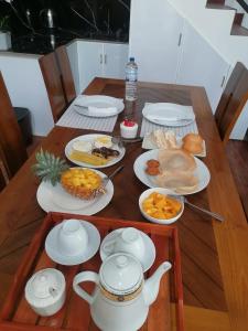 ein Tisch mit Tellern mit Essen und Teekannen darauf in der Unterkunft Mollusca Beach Villa in Waskaduwa