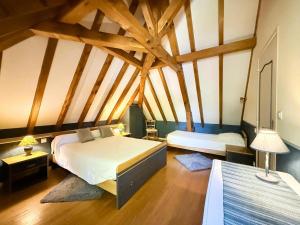 a bedroom with two beds in a room with wooden ceilings at Moulin gratia in Lay-Lamidou