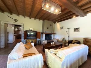 a living room with two white couches and a tv at Moulin gratia in Lay-Lamidou