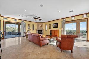 a living room with leather furniture and a fireplace at AUTHENTIC SANTA FE STYLE VILLA WITH PANORAMIC VIEWS in Gold Canyon