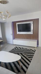 een woonkamer met een tv en een tafel en een tapijt bij DNY Home in Giurgiu