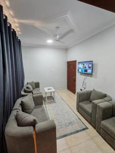 a living room with two couches and a flat screen tv at السعادة نستو - نسائم صلاله للأجنحة والشقق الفاخرة Nassayem Salalah Hotel Apartments & Suites Downtown in Salalah