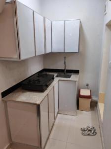 a small kitchen with a sink and a stove at السعادة نستو - نسائم صلاله للأجنحة والشقق الفاخرة Nassayem Salalah Hotel Apartments & Suites Downtown in Salalah