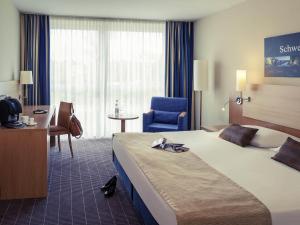 een hotelkamer met een groot bed en een stoel bij Mercure Hotel Schweinfurt Maininsel in Schweinfurt +59 foto's