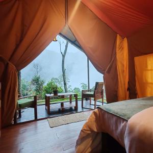 a room with a tent with a table and benches at Eco Wild Glamping Bambarakanda in Walhaputenna