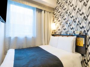 una stanza d'albergo con un letto e una finestra di APA Hotel Toyama Ekimae a Toyama Altre 67 foto