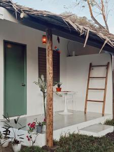 a house with a green door and a table and a ladder at Garden Village in El Nido