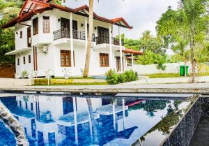 een huis met een zwembad ervoor bij Heaven villa mirissa in Mirissa