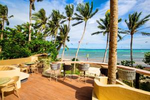 a patio with tables and chairs and the beach at Encantada Residences in Boracay