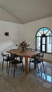 a wooden table with chairs and a vase of flowers on it at KAIA VILLAGE, Santa Teresa, Costa Rica in Santa Teresa Beach