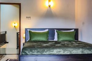 een slaapkamer met een blauw bed met groene kussens bij Heaven villa mirissa in Mirissa
