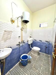 a bathroom with a toilet and a sink and a sink at Koraput Crown Homestay in Similigurha