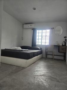 ein Schlafzimmer mit Bett, Schreibtisch und Fenster in der Unterkunft Phangan backpacker in Haad Rin