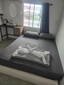ein Bett mit zwei Schwänen in einem Schlafzimmer in der Unterkunft Phangan backpacker in Haad Rin