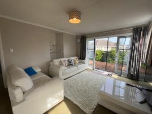 a living room with two white couches and a large window at A convenient stay in Hamilton
