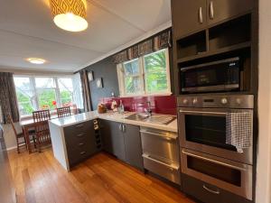 a kitchen with stainless steel appliances and a dining room at A convenient stay in Hamilton