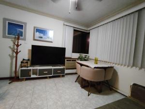 a living room with a television and a table and chairs at MiniSuite con vista al Río in Boca del Río