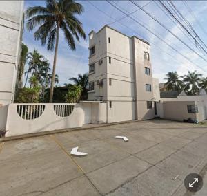 a building with a white arrow in a parking lot at MiniSuite con vista al Río in Boca del Río