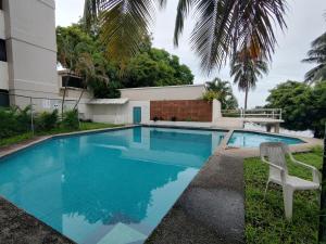 a swimming pool with a chair next to a house at MiniSuite con vista al Río in Boca del Río