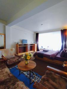 un soggiorno con un grande letto e un tavolo di Delohighs a Kalimpong