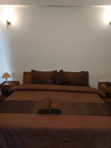 un grande letto con due paia di pantofole sopra di Delohighs a Kalimpong