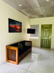 a room with a bed and a television on a wall at Ayurnest Pool Resort Wayanad in Batheri