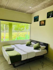 a large bed in a room with a window at Ayurnest Pool Resort Wayanad in Batheri +16 photos