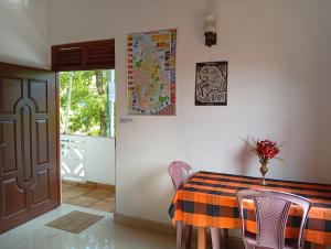 a dining room with a table and chairs and a door at Ameena Homestay in Tangalle