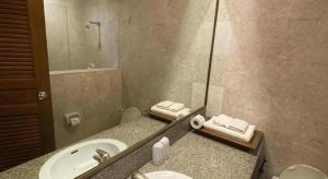 un bagno con lavandino e specchio di Sri U-Thong Grand Hotel a Suphanburi Altre 59 foto