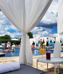 a view of a pool with people in the water at The Oriana Orange - Retro Hotel & Resort in Orange