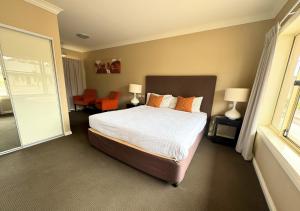 a bedroom with a large bed and a window at Sundowner Motel Hotel in Whyalla
