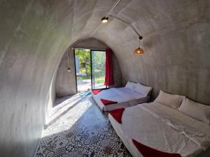 een kamer met twee bedden en een raam bij The Bear Bungalow in Kampot +36 foto's