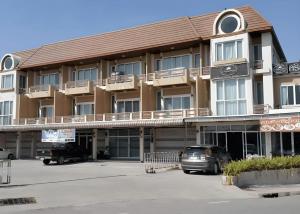 un grande edificio con auto parcheggiate in un parcheggio di Crystal Place Buayai a Bua Yai