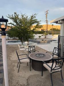 a patio with a table and chairs and a fire pit at Casa Pueblo in Desert Hot Springs
