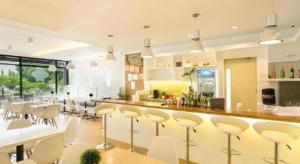 a kitchen with a bar with white stools at Venue 88 in Dulongabong