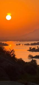 an orange sunset over a body of water at Centre point jawai in Bīsalpur