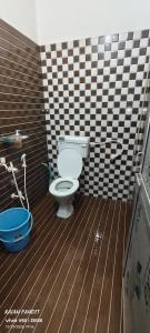 a bathroom with a toilet and a wooden floor at Sita pathik niwas in Jāmb +2 photos