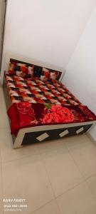a bed with a red quilt on it in a room at Sita pathik niwas in Jāmb