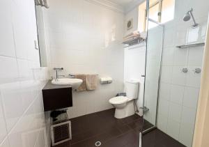 a bathroom with a toilet and a sink and a shower at Sundowner Motel Hotel in Whyalla