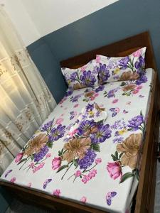 ein Bett mit lila und rosa Blumen drauf in der Unterkunft Le Centurion in Brazzaville