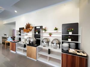 een restaurant met een bar met borden en gerechten bij Hotel Inayah Syariah in Kumprung