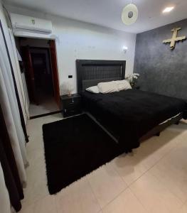 a bedroom with a large bed with a cross on the wall at suites vergel terraza in Orizaba