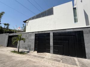 a building with two garage doors and a palm tree at suites vergel terraza in Orizaba