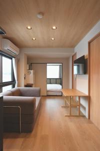 un soggiorno con un divano e un tavolo di AURA YUZAWA Apartment Hotel - 1Bedroom Apartment with Living Dining Kitchen Sleeps 2 to 4, Bedroom with 2-Double Bed, Living Room with 1-Sofa Bed a Yuzawa