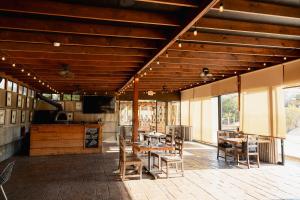 a restaurant with wooden ceilings and tables and chairs at OENO WINE LODGE Valle de Guadalupe in Valle de Guadalupe