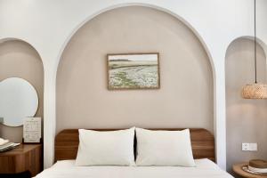 a bedroom with an archway above a bed with white pillows at Mê Stay Cát Bà in Cat Ba
