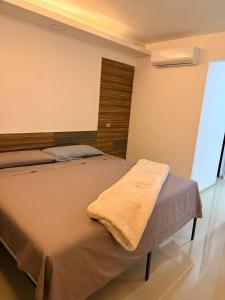 a bedroom with a bed with a blanket on it at Hermoso Departamento Moderno con alberca in Boca del Río