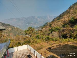 a view of a hill with mountains in the background at MK Devbhoomi Homestay in Kandikhal