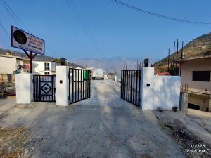 an entrance to a driveway with a gate at MK Devbhoomi Homestay in Kandikhal +7 photos